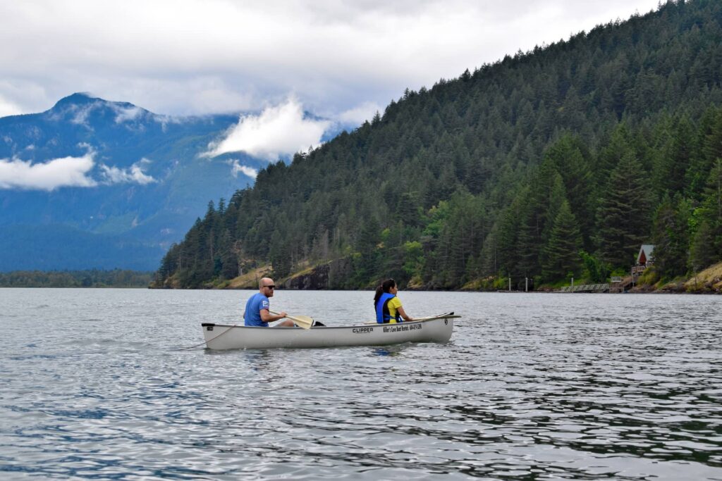 Man and woman floating down a river in a canoe.