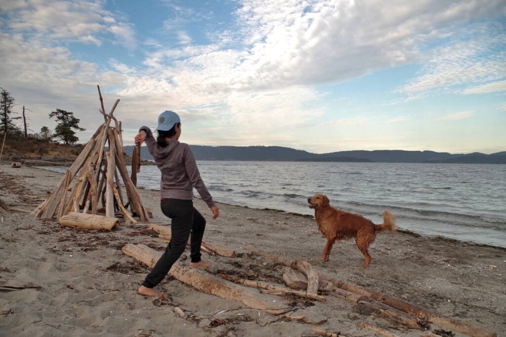 Ayelen playing with a dog at Walter Hook beach.